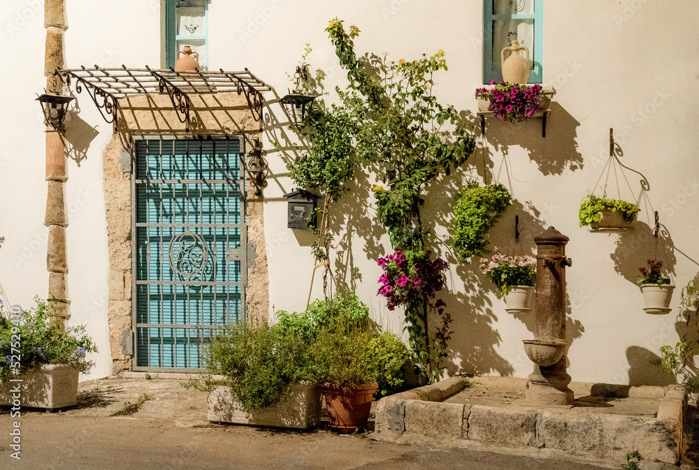 A picturesque glimpse of a street in Alliste with drinking fountain and decorative plants, Alliste, province of Lecce, Salento, Italy