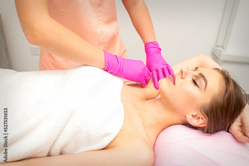 Waxing. Depilation under the armpits of the young woman lying with closed eyes in the spa salon Waxing. Depilation under the armpits of the young woman lying with closed eyes in the spa salon