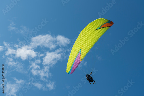 Paraglider pilot plot a turn overlooking the Atlantic coast with the sky in the background.