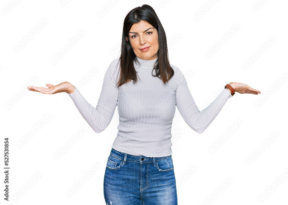 Beautiful brunette woman wearing casual clothes clueless and confused expression with arms and hands raised. doubt concept. Beautiful brunette woman wearing casual clothes clueless and confused expression with arms and hands raised. doubt concept.