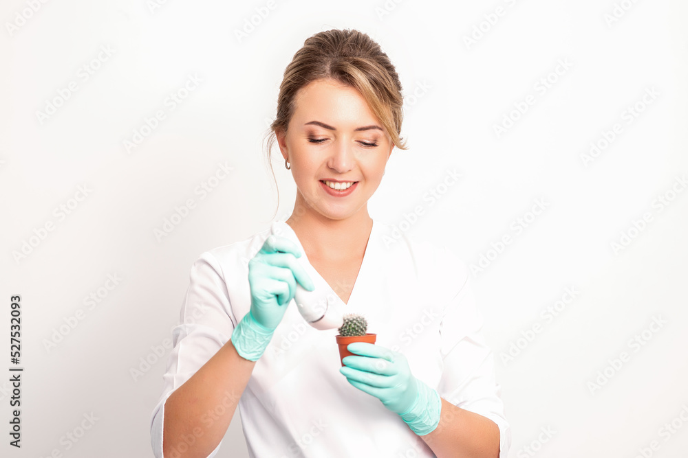 A smiling female beautician holds little green cactus with the razor in her hands. Hair removal concept A smiling female beautician holds little green cactus with the razor in her hands. Hair removal concept