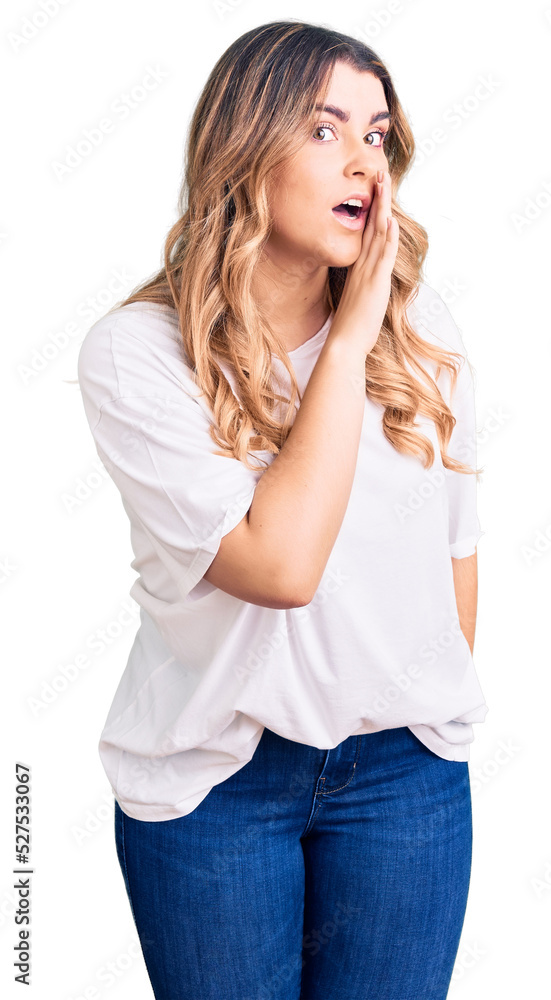 Young caucasian woman wearing casual clothes hand on mouth telling secret rumor, whispering malicious talk conversation Young caucasian woman wearing casual clothes hand on mouth telling secret rumor, whispering malicious talk conversation