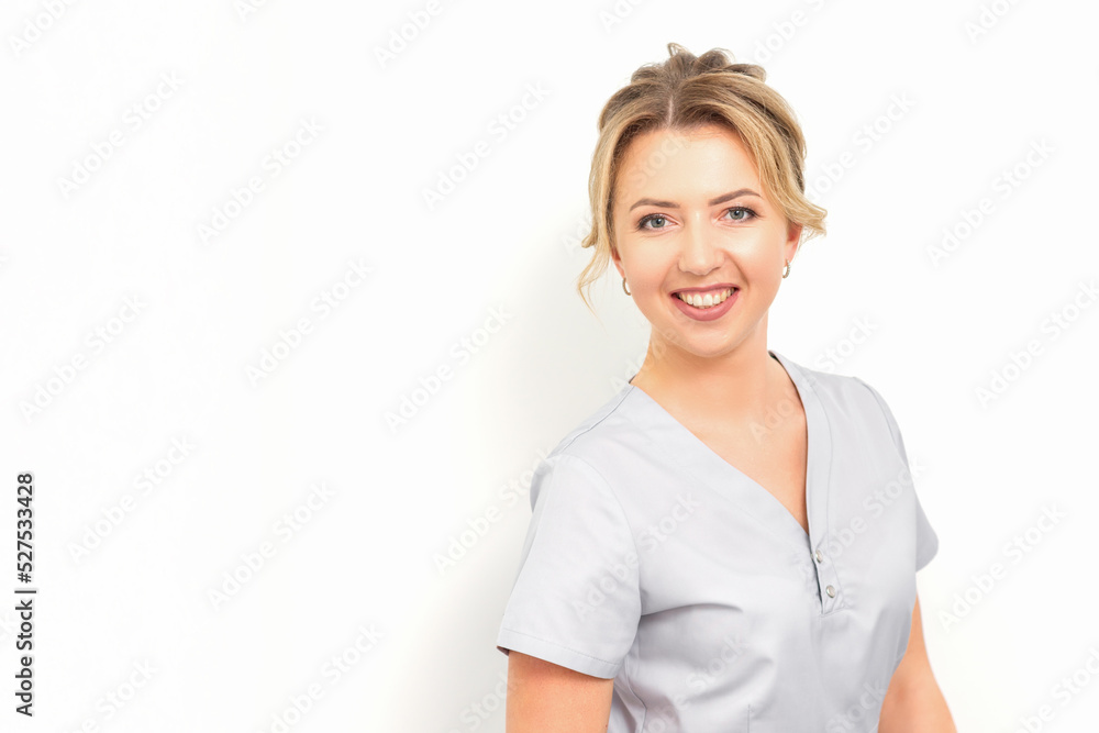 Close-up portrait of young smiling female caucasian healthcare worker standing staring at the camera on white background Close-up portrait of young smiling female caucasian healthcare worker standing staring at the camera on white background