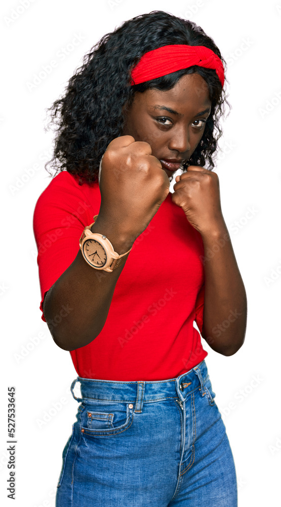 Beautiful african young woman wearing casual clothes ready to fight with fist defense gesture, angry and upset face, afraid of problem Beautiful african young woman wearing casual clothes ready to fight with fist defense gesture, angry and upset face, afraid of problem