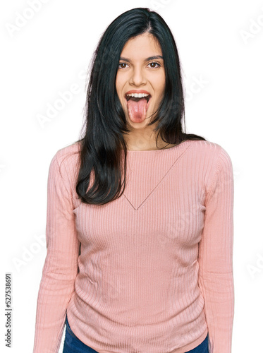 Young hispanic woman wearing casual clothes sticking tongue out happy with funny expression. emotion concept.