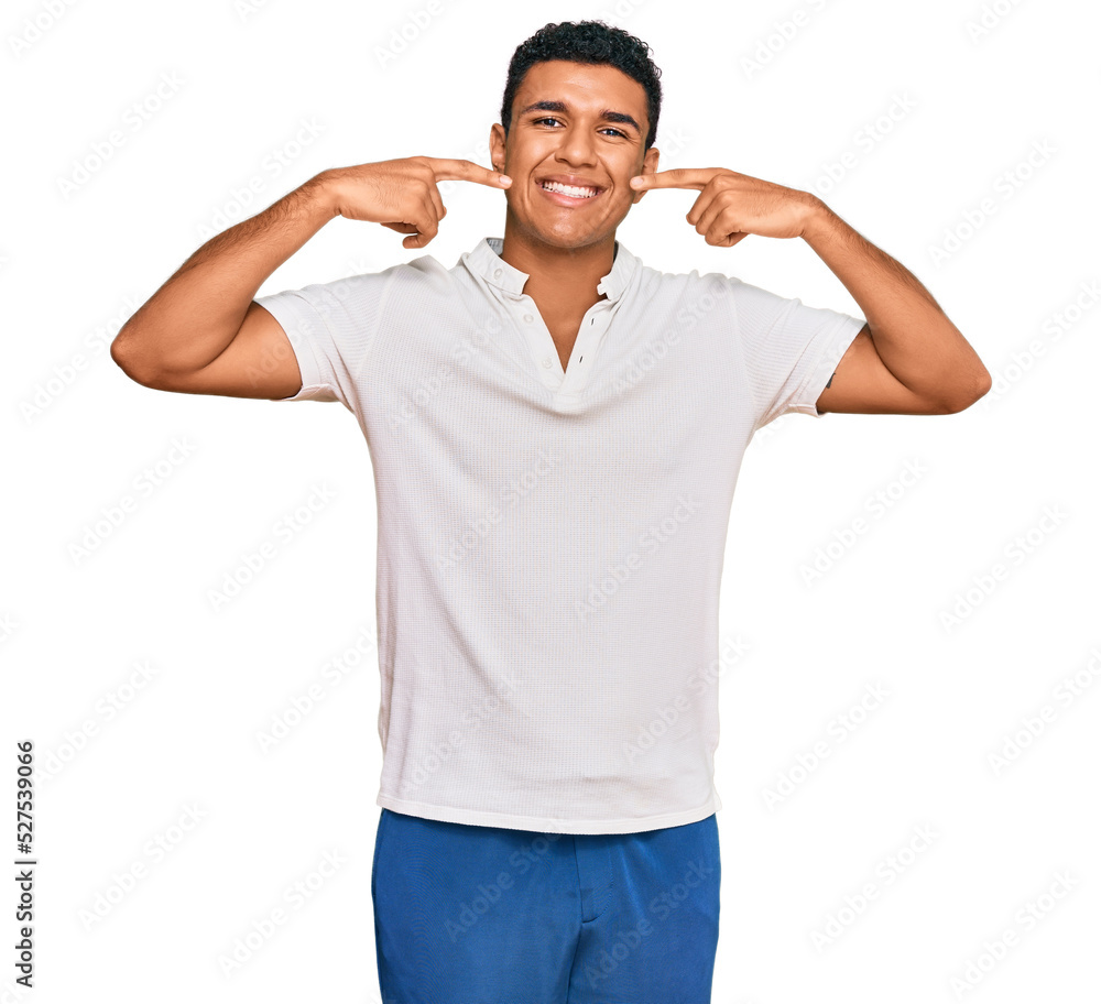 Young arab man wearing casual clothes smiling cheerful showing and pointing with fingers teeth and mouth. dental health concept. Young arab man wearing casual clothes smiling cheerful showing and pointing with fingers teeth and mouth. dental health concept.