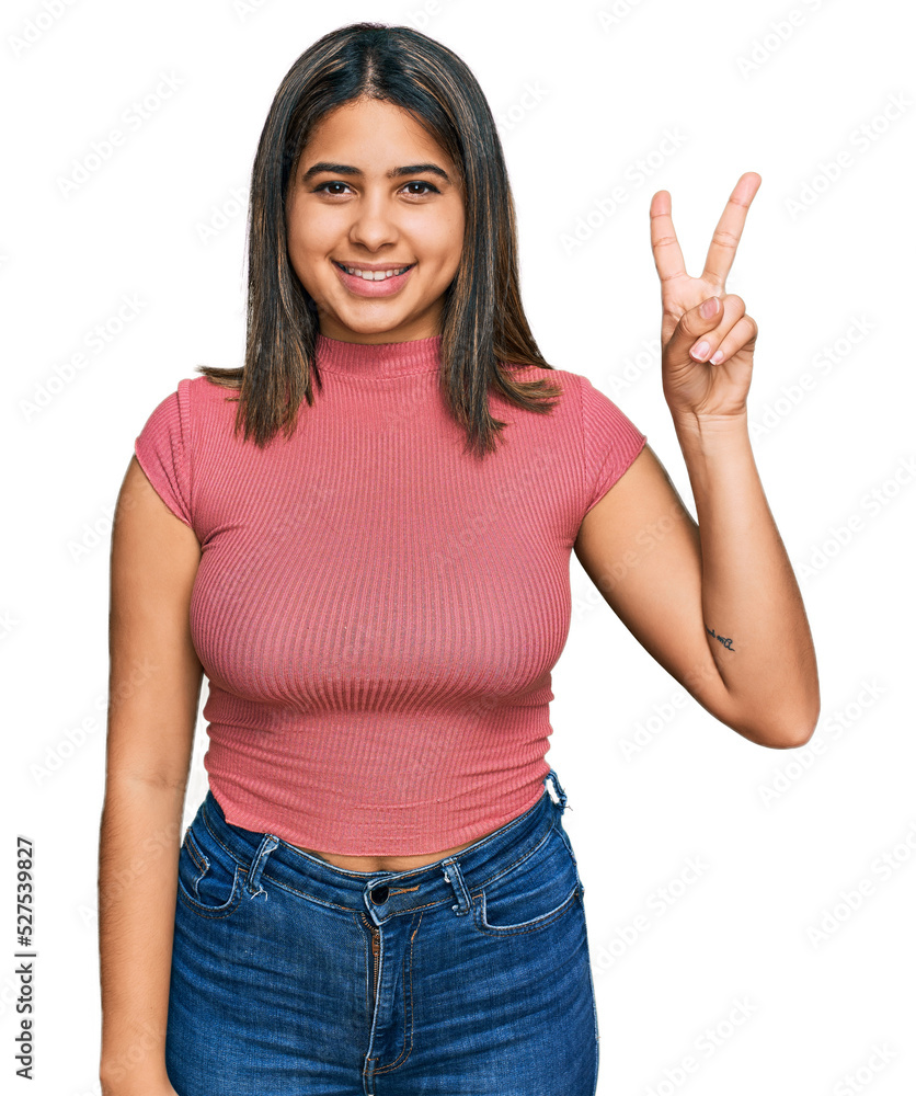 Young hispanic girl wearing casual t shirt showing and pointing up with fingers number two while smiling confident and happy. Young hispanic girl wearing casual t shirt showing and pointing up with fingers number two while smiling confident and happy.