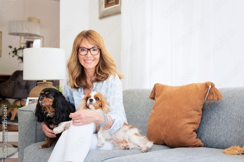 Happy woman with her cute puppies relaxing at home Happy woman with her cute puppies relaxing at home