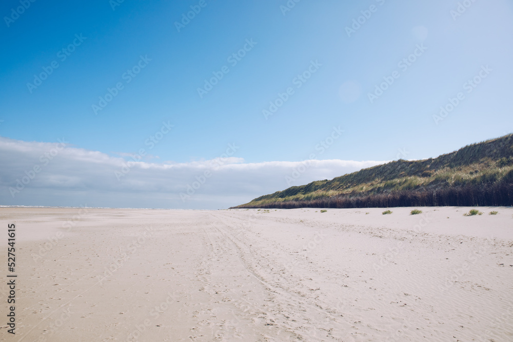 Wide sandy beach on the North Sea. Beach by the sea in Holland, Germany or Denmark. dunes by the sea