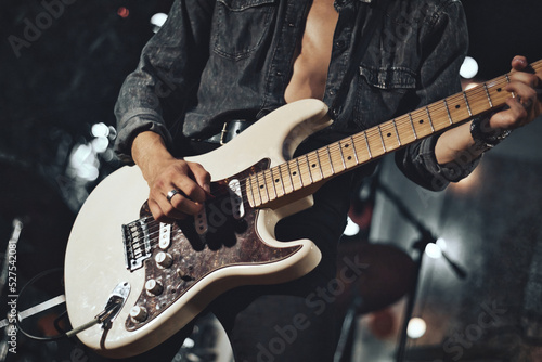 Close-up of rock musician guitarist playing the electric guitar on stage photo