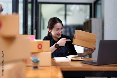 Young start up business woman asian working as SME entrepreneur new business with packaging box, preparing for send to client. © Natee Meepian