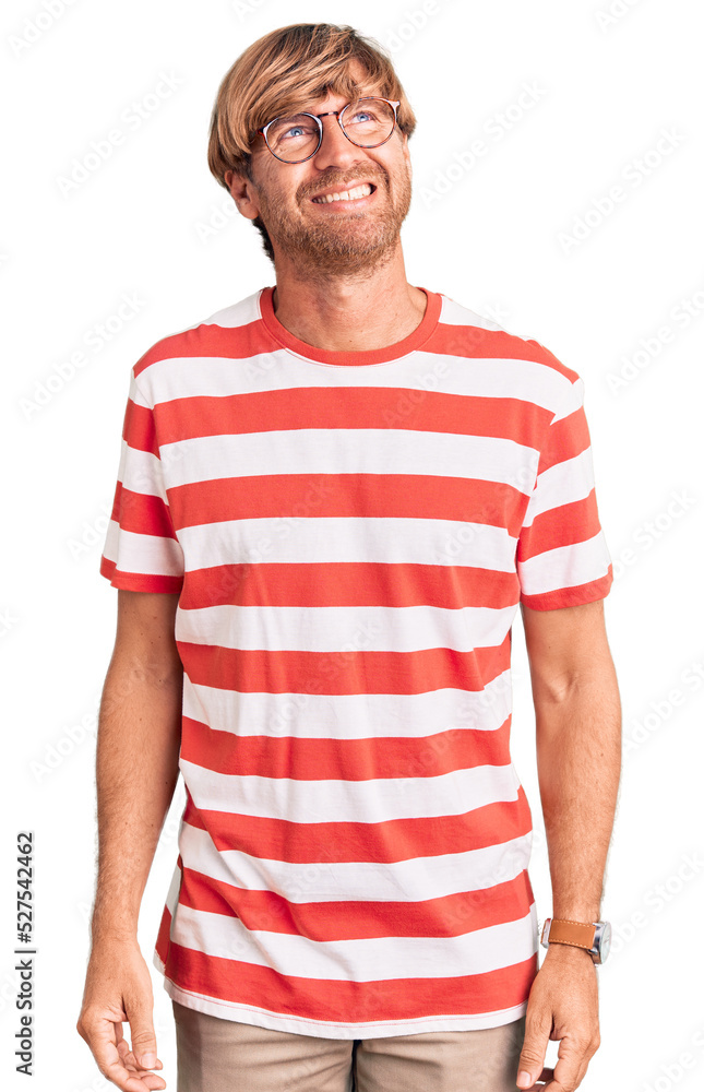 Handsome caucasian man with beard wearing casual clothes and glasses looking away to side with smile on face, natural expression. laughing confident. Handsome caucasian man with beard wearing casual clothes and glasses looking away to side with smile on face, natural expression. laughing confident.