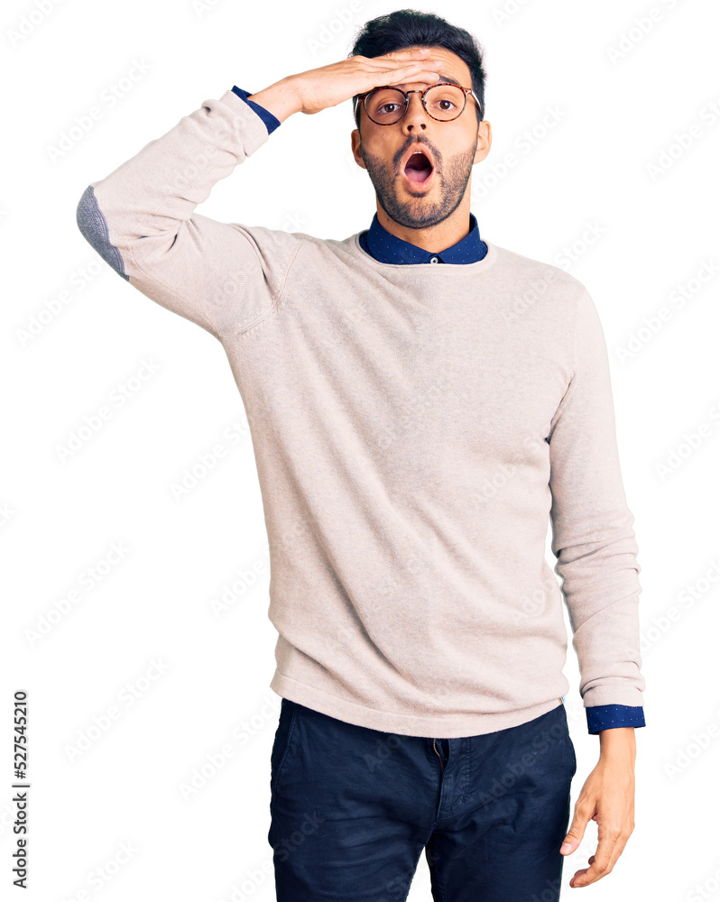 Young handsome hispanic man wearing elegant clothes and glasses surprised with hand on head for mistake, remember error. forgot, bad memory concept. Young handsome hispanic man wearing elegant clothes and glasses surprised with hand on head for mistake, remember error. forgot, bad memory concept.
