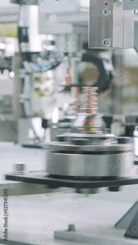 Vertical video of Advanced robotic machine manufacturing parts in an automated assembly line