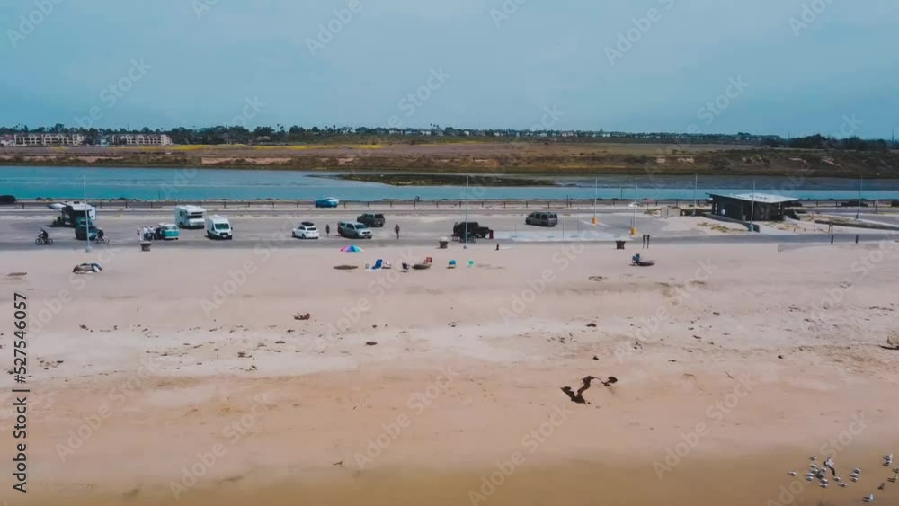 High flying angle shot of beach with cars parking and driving along highway. High flying angle shot of beach with cars parking and driving along highway.