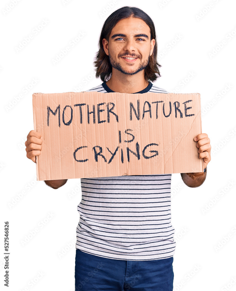 Young handsome man holding mother nature is crying protest cardboard banner looking positive and happy standing and smiling with a confident smile showing teeth Young handsome man holding mother nature is crying protest cardboard banner looking positive and happy standing and smiling with a confident smile showing teeth