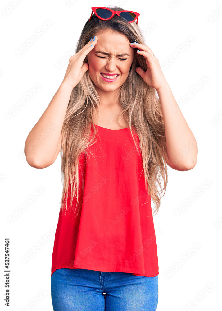 Young beautiful blonde woman wearing sleeveless t-shirt and sunglasses with hand on head for pain in head because stress. suffering migraine. Young beautiful blonde woman wearing sleeveless t-shirt and sunglasses with hand on head for pain in head because stress. suffering migraine.