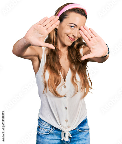 Young caucasian woman wearing casual style with sleeveless shirt doing frame using hands palms and fingers, camera perspective