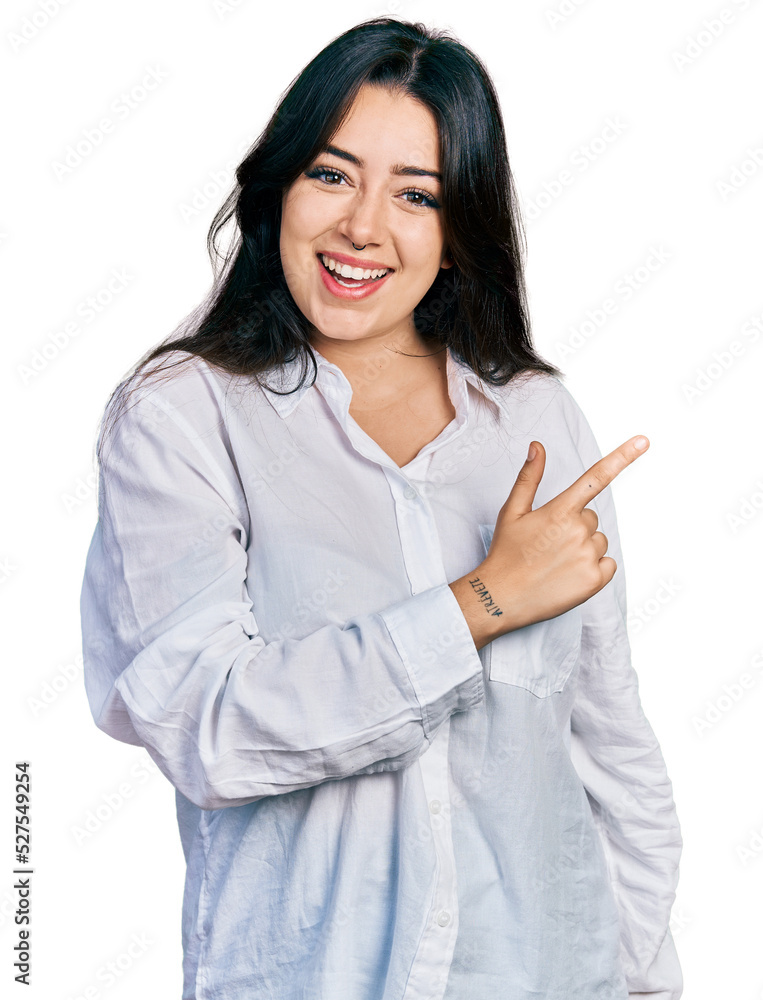 Beautiful hispanic woman wearing casual white shirt cheerful with a smile of face pointing with hand and finger up to the side with happy and natural expression on face Beautiful hispanic woman wearing casual white shirt cheerful with a smile of face pointing with hand and finger up to the side with happy and natural expression on face