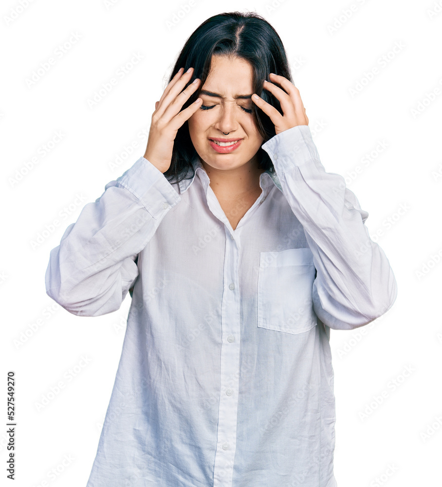 Beautiful hispanic woman wearing casual white shirt with hand on head for pain in head because stress. suffering migraine. Beautiful hispanic woman wearing casual white shirt with hand on head for pain in head because stress. suffering migraine.
