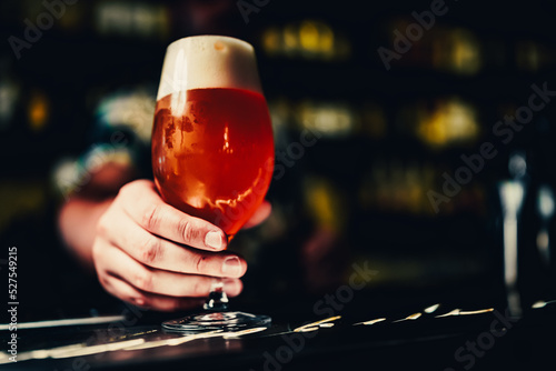 bartender s hand hold full glass of beer in a bar