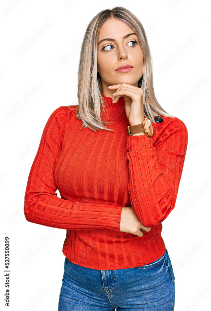 Beautiful blonde woman wearing casual clothes with hand on chin thinking about question, pensive expression. smiling with thoughtful face. doubt concept. Beautiful blonde woman wearing casual clothes with hand on chin thinking about question, pensive expression. smiling with thoughtful face. doubt concept.