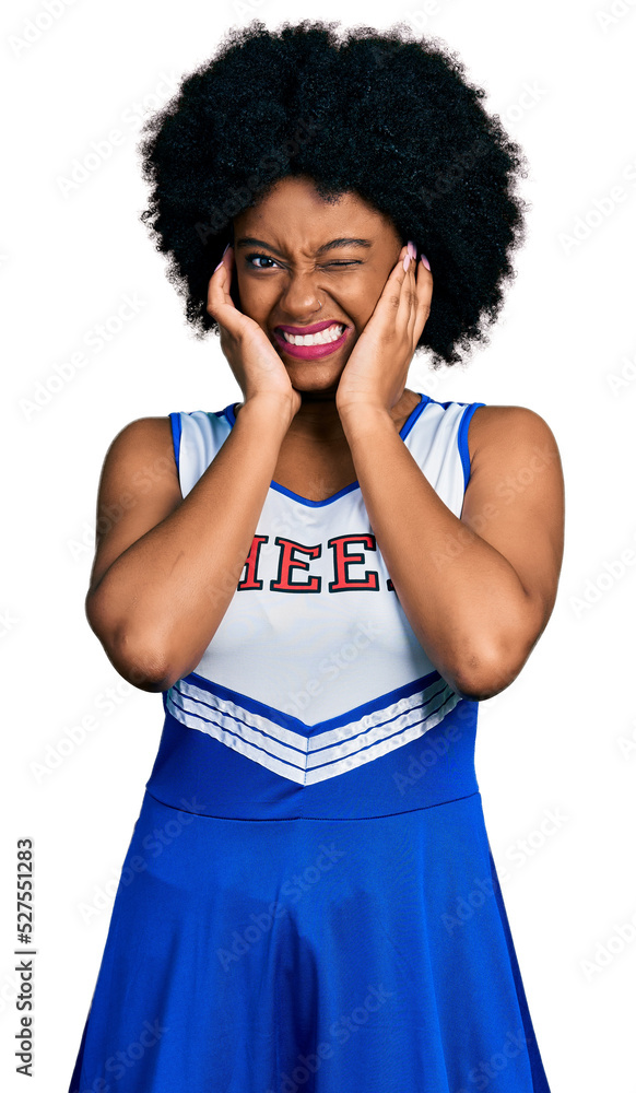 Young african american woman wearing cheerleader uniform covering ears with fingers with annoyed expression for the noise of loud music. deaf concept. Young african american woman wearing cheerleader uniform covering ears with fingers with annoyed expression for the noise of loud music. deaf concept.