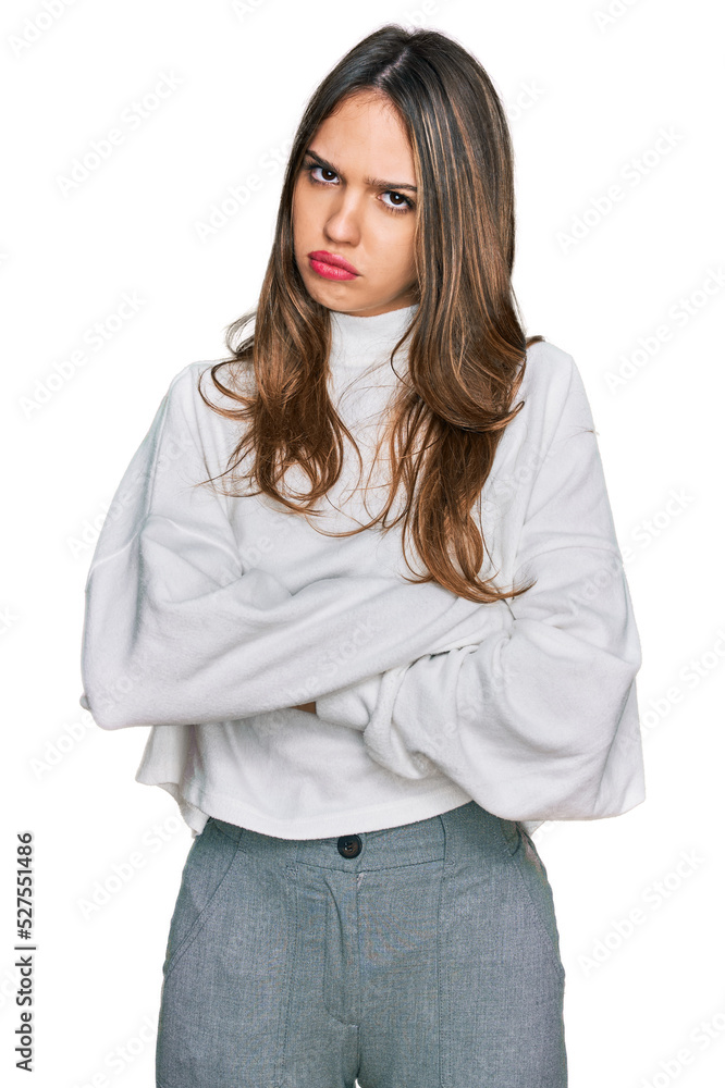 Young brunette woman wearing casual turtleneck sweater skeptic and nervous, disapproving expression on face with crossed arms. negative person. Young brunette woman wearing casual turtleneck sweater skeptic and nervous, disapproving expression on face with crossed arms. negative person.