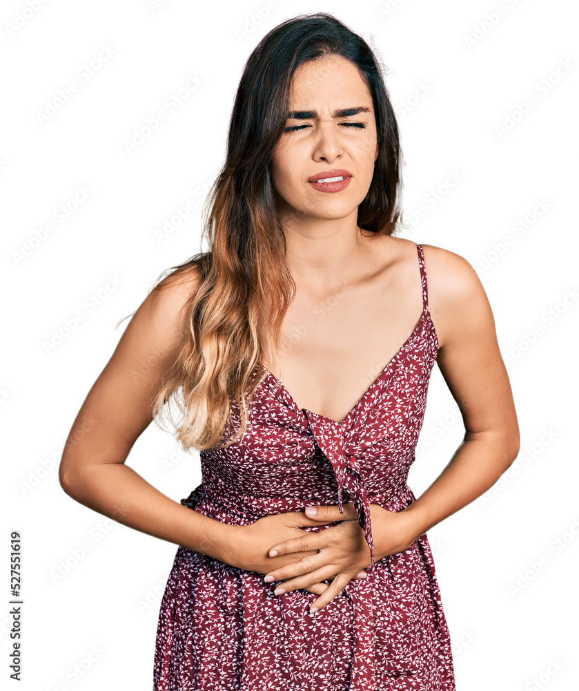 Beautiful hispanic woman wearing summer dress with hand on stomach because nausea, painful disease feeling unwell. ache concept. Beautiful hispanic woman wearing summer dress with hand on stomach because nausea, painful disease feeling unwell. ache concept.