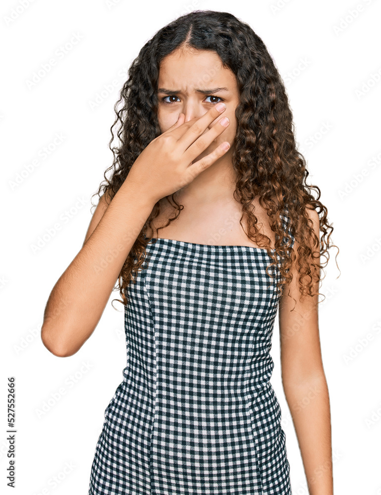 Teenager hispanic girl wearing casual clothes smelling something stinky and disgusting, intolerable smell, holding breath with fingers on nose. bad smell Teenager hispanic girl wearing casual clothes smelling something stinky and disgusting, intolerable smell, holding breath with fingers on nose. bad smell