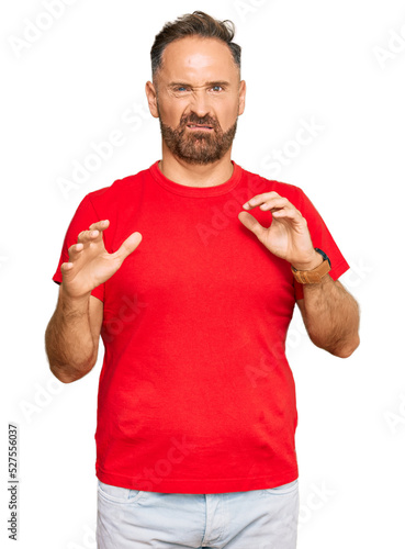 Handsome middle age man wearing casual red tshirt disgusted expression, displeased and fearful doing disgust face because aversion reaction. with hands raised