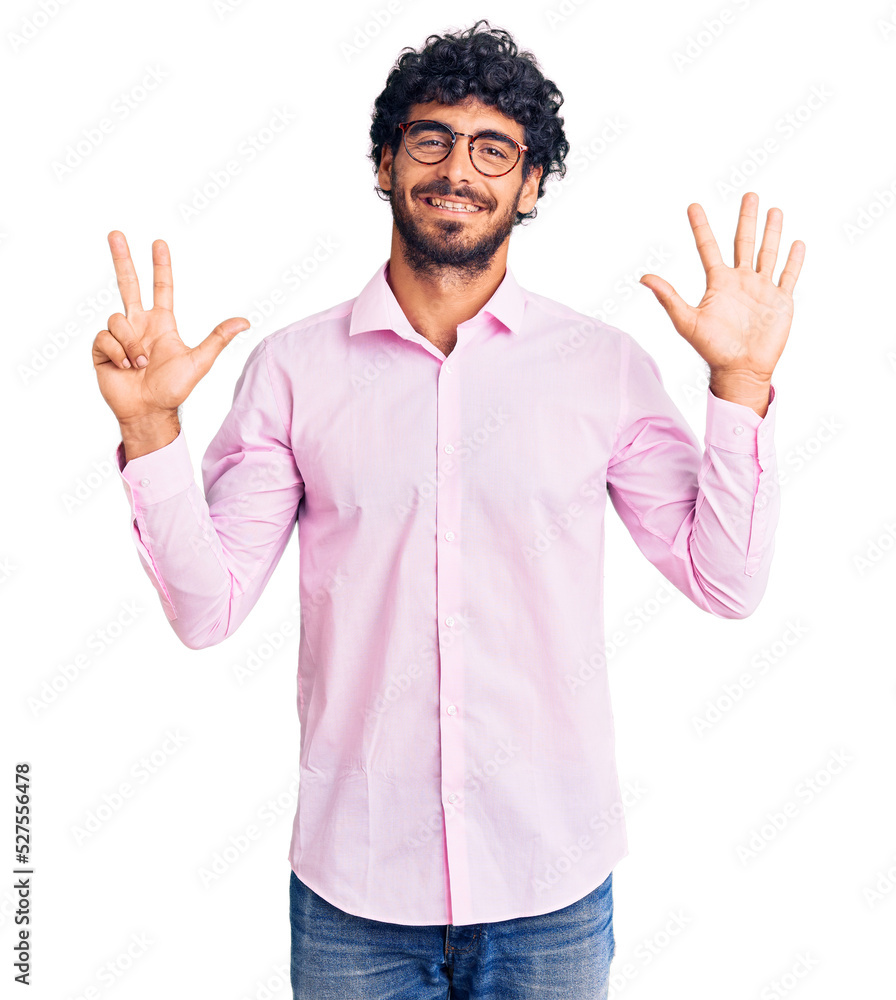 Handsome young man with curly hair and bear wearing business clothes showing and pointing up with fingers number eight while smiling confident and happy. Handsome young man with curly hair and bear wearing business clothes showing and pointing up with fingers number eight while smiling confident and happy.
