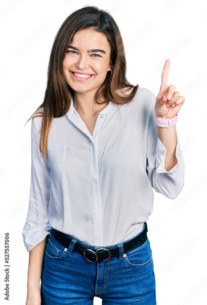 Young caucasian girl wearing casual white shirt showing and pointing up with finger number one while smiling confident and happy. Young caucasian girl wearing casual white shirt showing and pointing up with finger number one while smiling confident and happy.