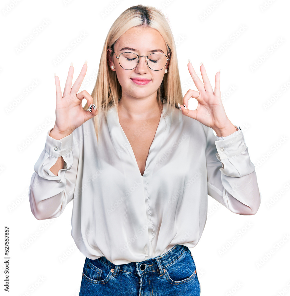Beautiful blonde woman wearing elegant shirt and glasses relaxed and smiling with eyes closed doing meditation gesture with fingers. yoga concept. Beautiful blonde woman wearing elegant shirt and glasses relaxed and smiling with eyes closed doing meditation gesture with fingers. yoga concept.