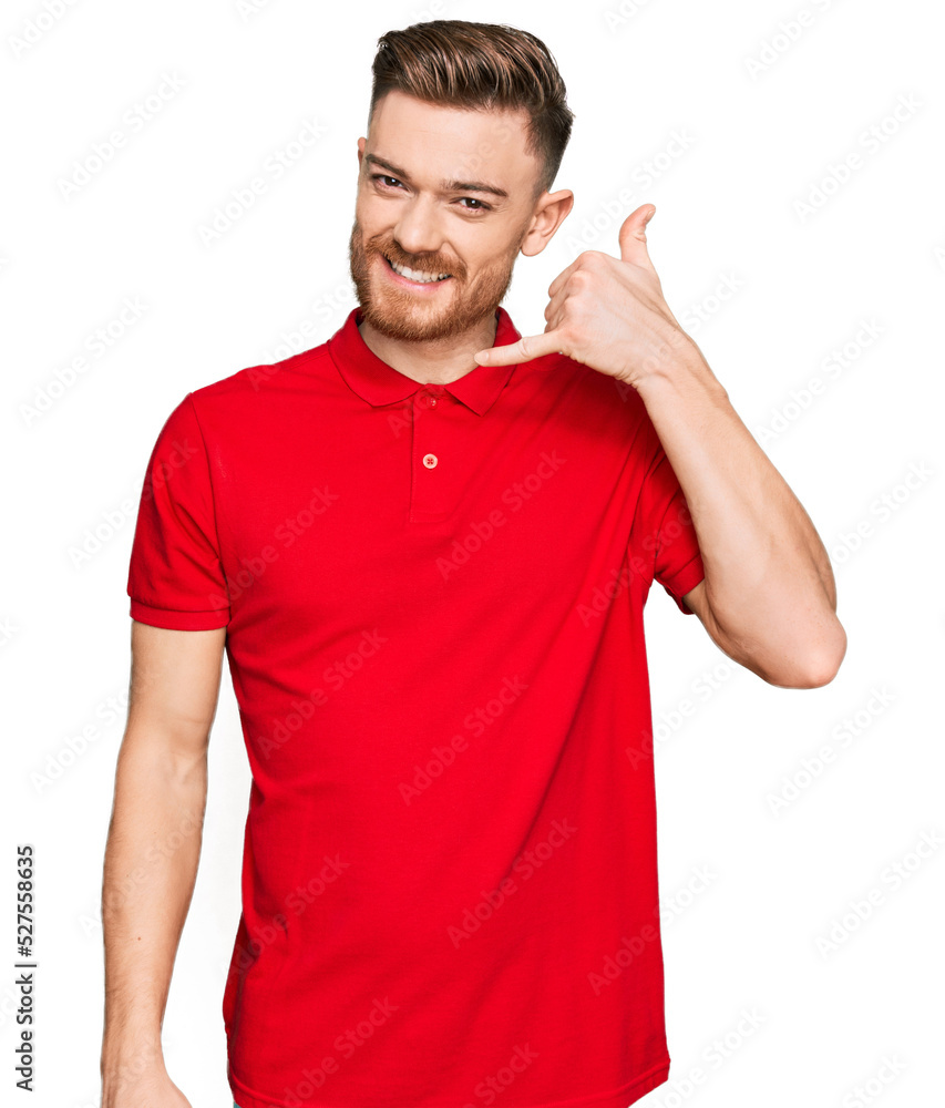 Young redhead man wearing casual clothes smiling doing phone gesture with hand and fingers like talking on the telephone. communicating concepts. Young redhead man wearing casual clothes smiling doing phone gesture with hand and fingers like talking on the telephone. communicating concepts.