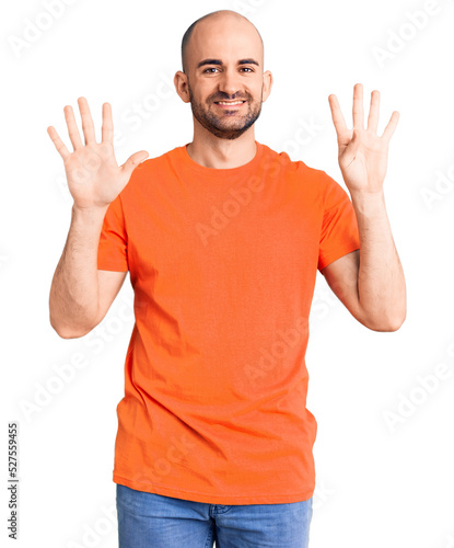 Young handsome man wering casual t shirt showing and pointing up with fingers number nine while smiling confident and happy.