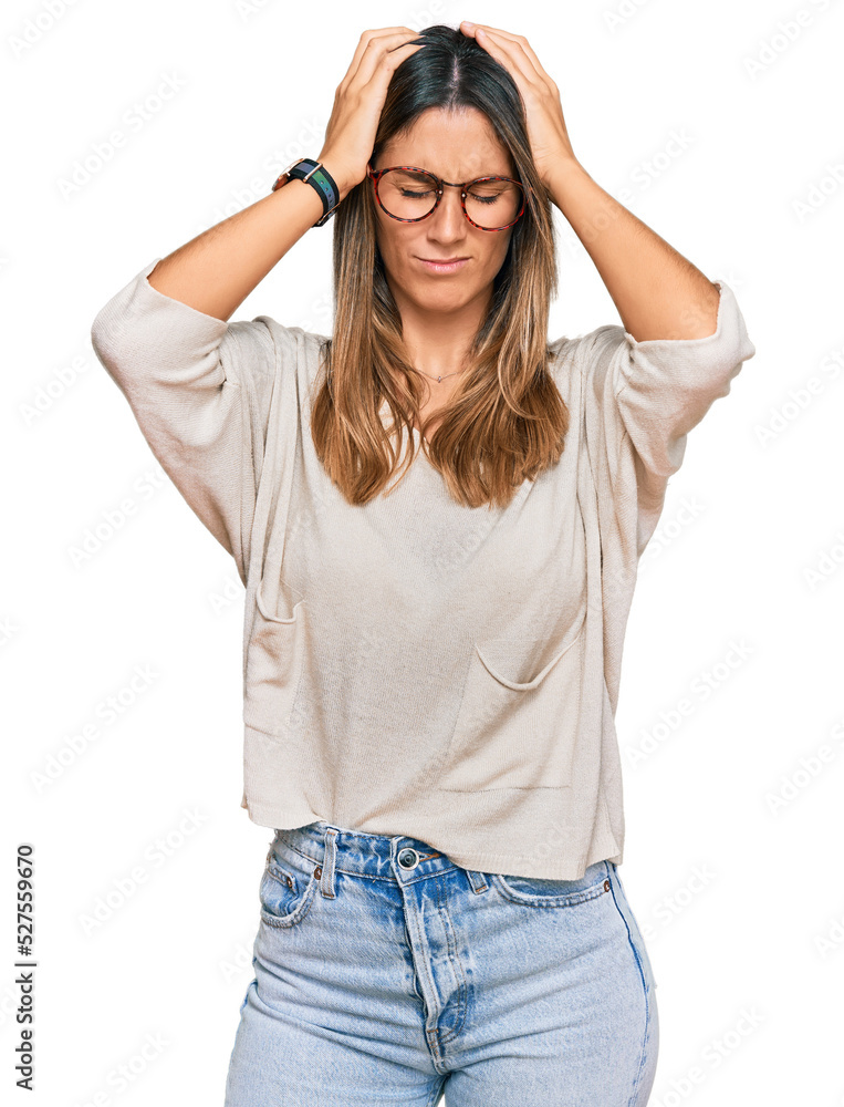Young woman wearing casual clothes and glasses suffering from headache desperate and stressed because pain and migraine. hands on head. Young woman wearing casual clothes and glasses suffering from headache desperate and stressed because pain and migraine. hands on head.
