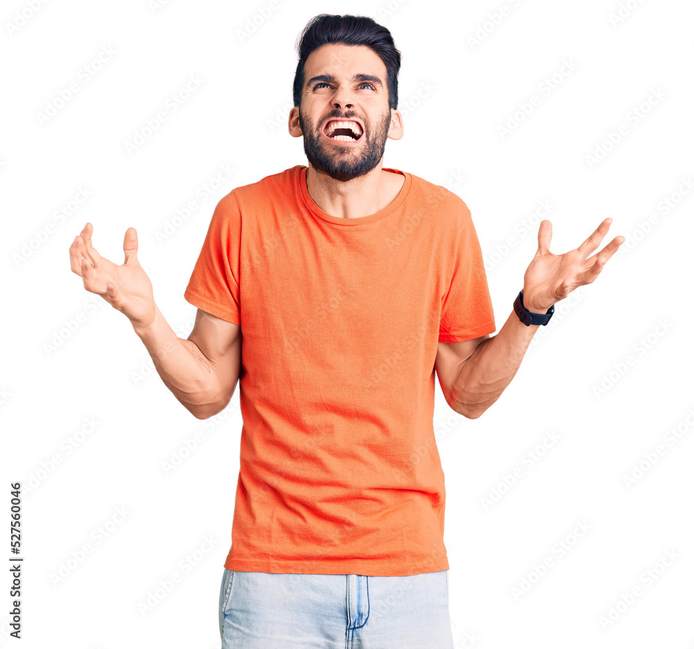 Young handsome man with beard wearing casual t-shirt crazy and mad shouting and yelling with aggressive expression and arms raised. frustration concept. Young handsome man with beard wearing casual t-shirt crazy and mad shouting and yelling with aggressive expression and arms raised. frustration concept.