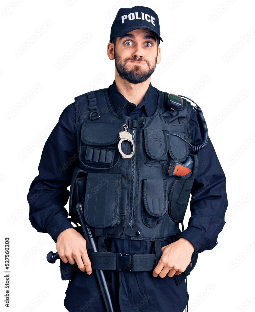 Young handsome man with beard wearing police uniform puffing cheeks with funny face. mouth inflated with air, crazy expression. Young handsome man with beard wearing police uniform puffing cheeks with funny face. mouth inflated with air, crazy expression.
