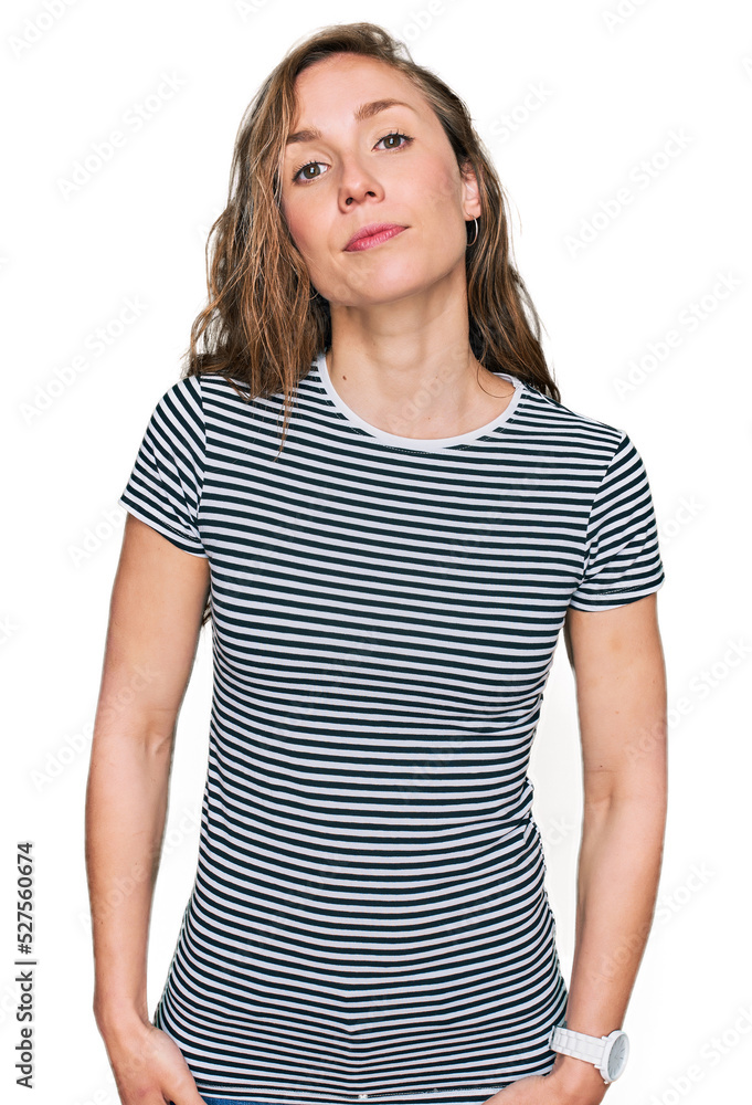 Young blonde woman wearing casual clothes relaxed with serious expression on face. simple and natural looking at the camera. Young blonde woman wearing casual clothes relaxed with serious expression on face. simple and natural looking at the camera.