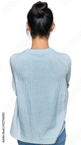 Young hispanic woman wearing casual clothes standing backwards looking away with crossed arms