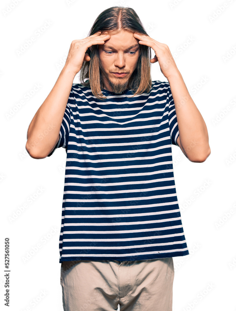 Handsome caucasian man with long hair wearing casual striped t-shirt with hand on head for pain in head because stress. suffering migraine. Handsome caucasian man with long hair wearing casual striped t-shirt with hand on head for pain in head because stress. suffering migraine.