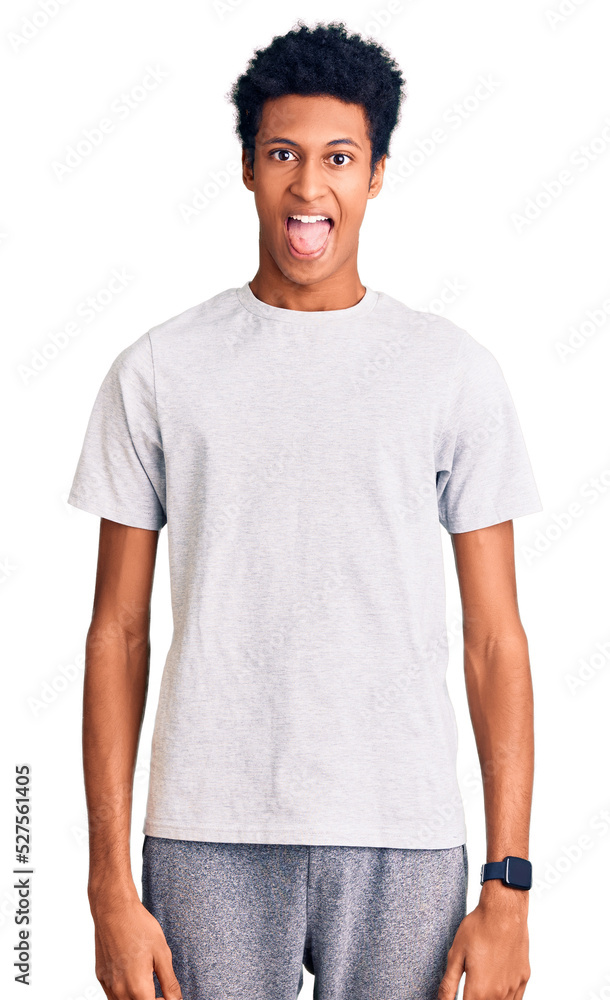 Young african american man wearing casual clothes sticking tongue out happy with funny expression. emotion concept. Young african american man wearing casual clothes sticking tongue out happy with funny expression. emotion concept.