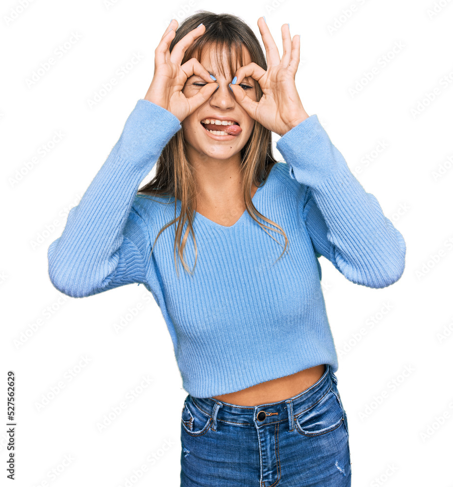 Teenager caucasian girl wearing casual clothes doing ok gesture like binoculars sticking tongue out, eyes looking through fingers. crazy expression. Teenager caucasian girl wearing casual clothes doing ok gesture like binoculars sticking tongue out, eyes looking through fingers. crazy expression.