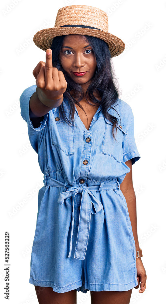 Young indian girl wearing summer hat showing middle finger, impolite and rude fuck off expression Young indian girl wearing summer hat showing middle finger, impolite and rude fuck off expression