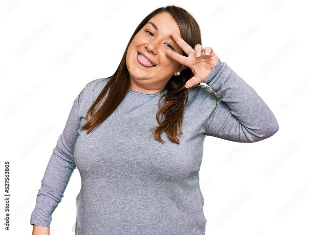Beautiful brunette plus size woman wearing casual clothes doing peace symbol with fingers over face, smiling cheerful showing victory Beautiful brunette plus size woman wearing casual clothes doing peace symbol with fingers over face, smiling cheerful showing victory