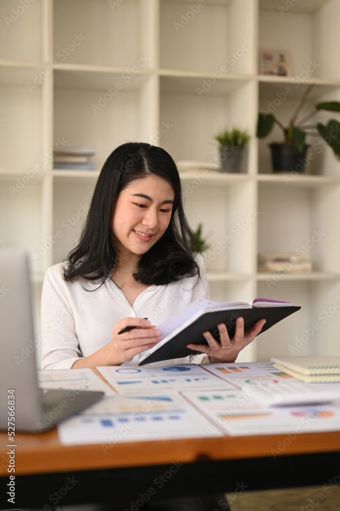 Professional businesswoman using laptop and working with document on office desk Professional businesswoman using laptop and working with document on office desk