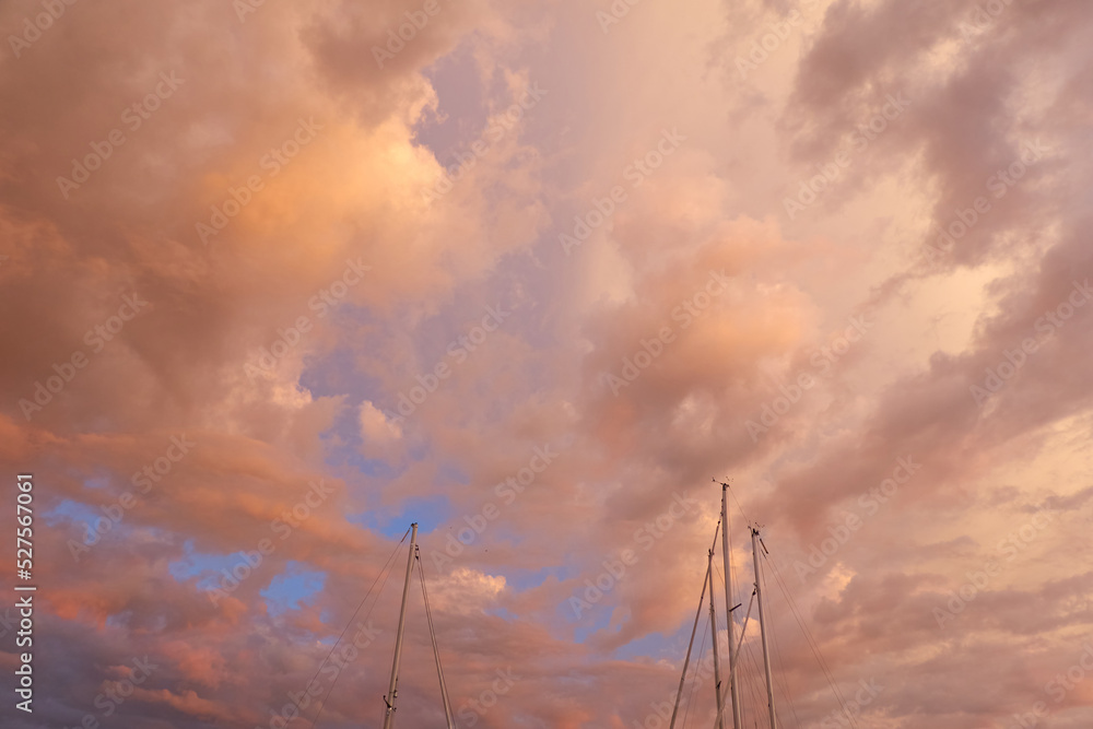 Yacht mast against colorful sunset sky with glowing cirrus and cumulus clouds after the storm. Transportation, cruise, sport, sailing, yachting. Wanderlust, inspiration concepts