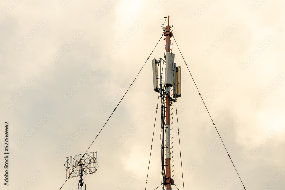 New GSM antennas on a high tower against a blue sky for transmitting a