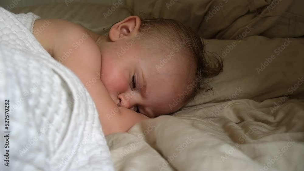 Peaceful adorable baby sleeping on his bed at home. Sleeping newborn baby concept. One year old baby girl sleeps peaceful at domestic room interior background. A serene dream. Face Close Up. Peaceful adorable baby sleeping on his bed at home. Sleeping newborn baby concept. One year old baby girl sleeps peaceful at domestic room interior background. A serene dream. Face Close Up.
